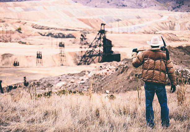istock Tough man stands in rock quarry with old oil drill 500389699