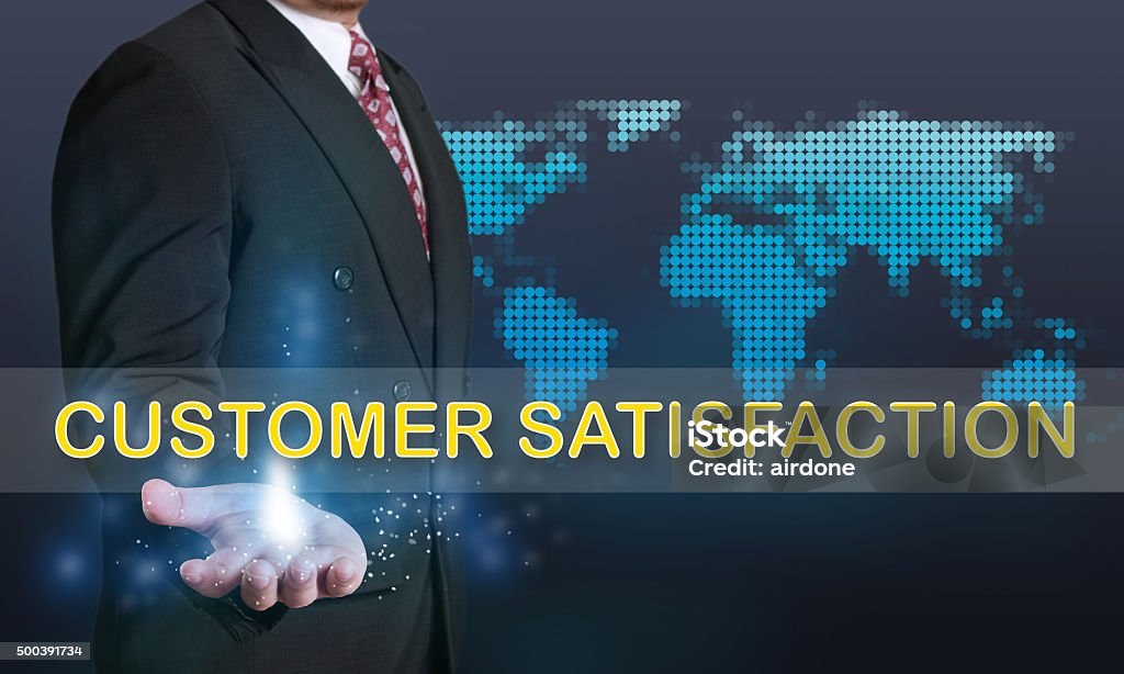 Customer Satisfaction, Business Concept Business concept image of a businessman showing Customer Satisfaction words on his hand over blue background with dotted world map 2015 Stock Photo