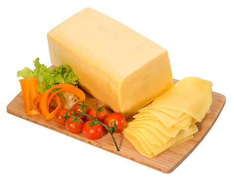 Block of yellow cheese with slices on a cutting board,isolated on white with clipping path.