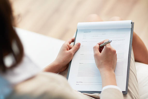 Medical record Female counselor writing down some information about her patient form filling stock pictures, royalty-free photos & images