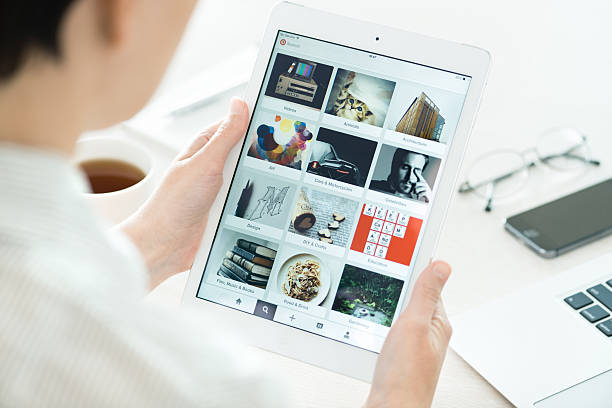 Pinterest boards on Apple iPad Air Kiev, Ukraine - June 27, 2014: Woman looking on Pinterest application boards on modern white Apple iPad Air, which is designed and developed by Apple inc. and was released on November 1, 2013. brand name photos stock pictures, royalty-free photos & images
