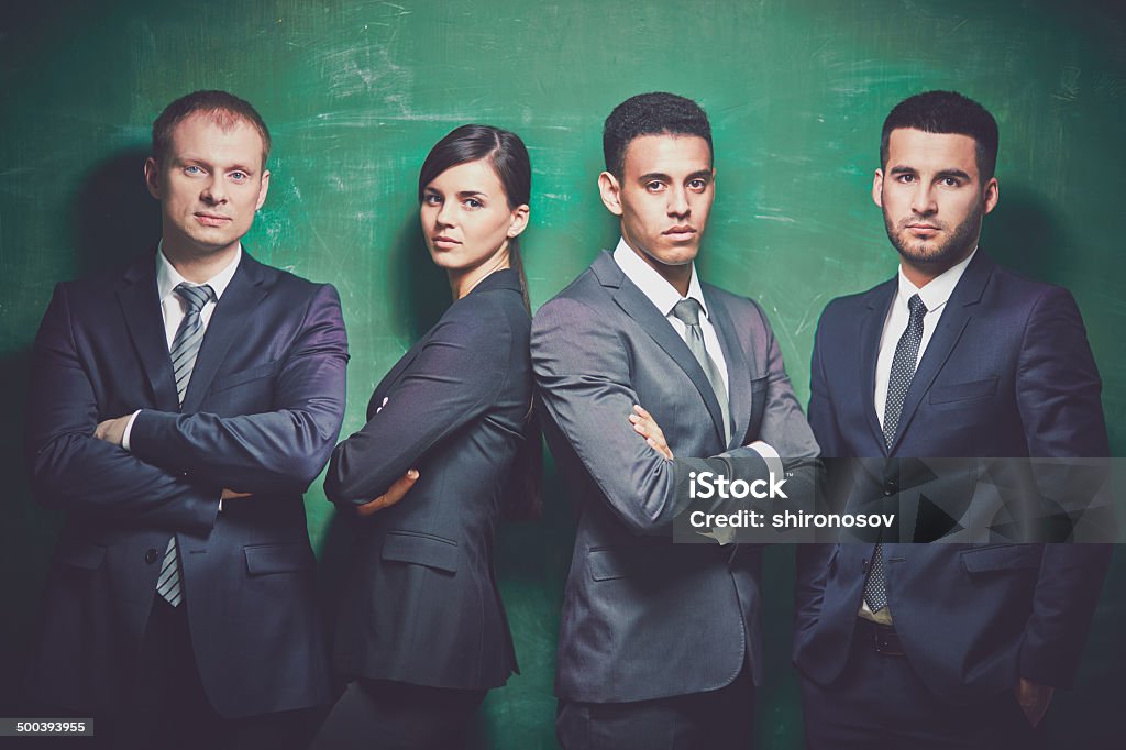 Group of employees Group of elegant business partners looking at camera on green background Adult Stock Photo