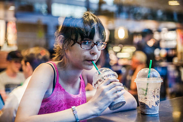 Girl drinks iced coffe in a cafe
