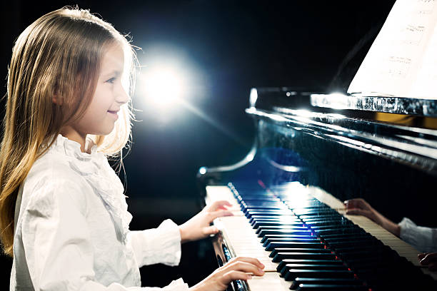 Side view of little girl playing the piano.  