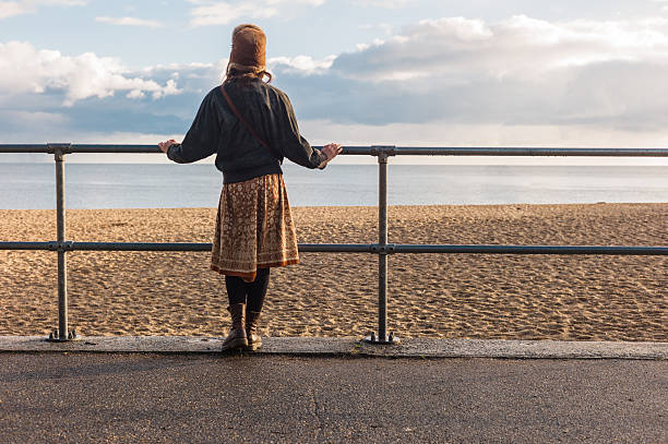 istock Woman standing by railings on beach 500396768