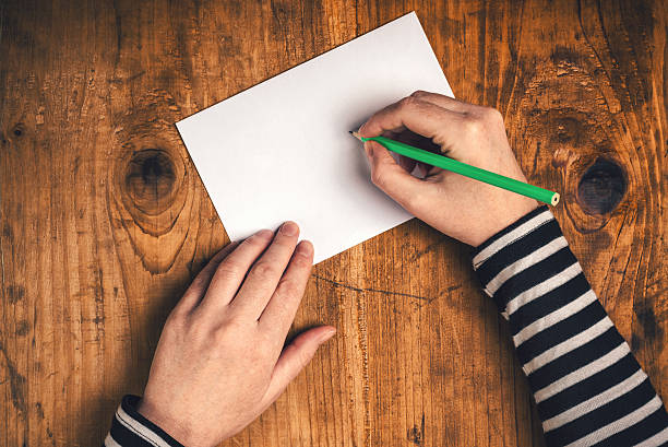 istock Woman writing recipient address on mailing envelope 500400810