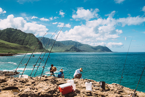 Ka'ena Point State Park, Oahu, USA - July 23, 2015: Hawaiian Family Fishing from the cliffs at Ka'ena Point State Park in Oahu. Hawaii