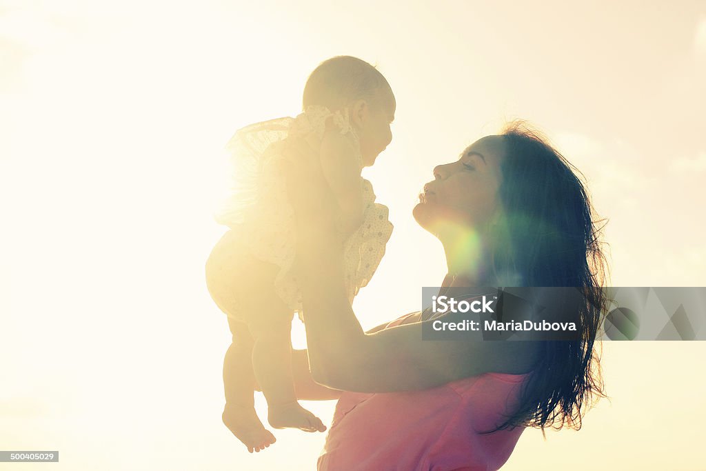 Silhouette of mother and baby Silhouette of mother and baby at sunset Mother Stock Photo