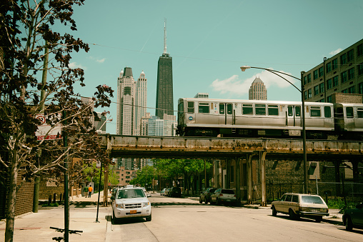 Elevated metra train bringing commuters to work in front of the skyline of Chicago. 