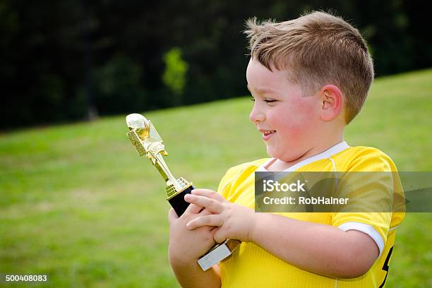 Young Boy With Yellow Jersey Holding Trophy Stock Photo - Download Image Now - Boys, First Place, Trophy - Award