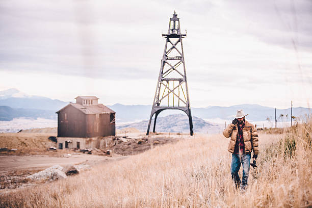 istock Cowboy talking on phone and walking through western field 500408655