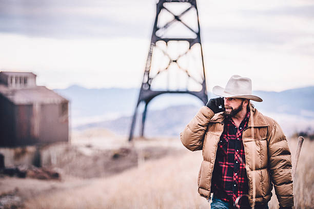 istock Western man talking on phone and walking by oil drill 500408671