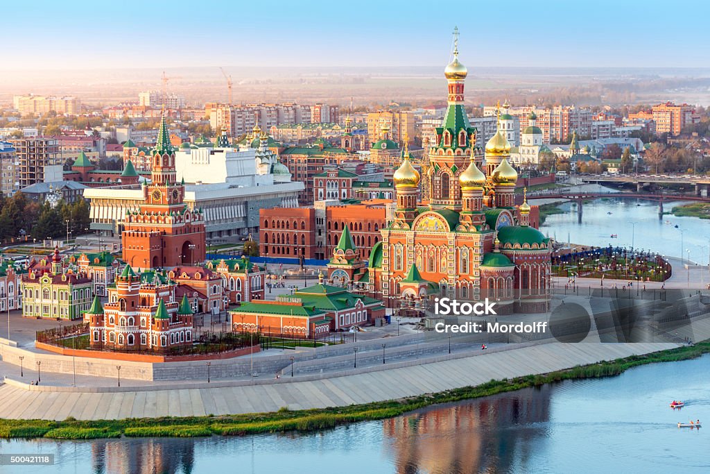 Nice Russian Town On River Nice view of the town at sunset. Orthodox church surrounded by beautiful red brick buildings on the city's waterfront. Volga region of Russia, the city of Yoshkar-Ola Kremlin Stock Photo