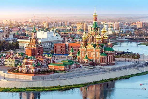 Nice view of the town at sunset. Orthodox church surrounded by beautiful red brick buildings on the city's waterfront. Volga region of Russia, the city of Yoshkar-Ola