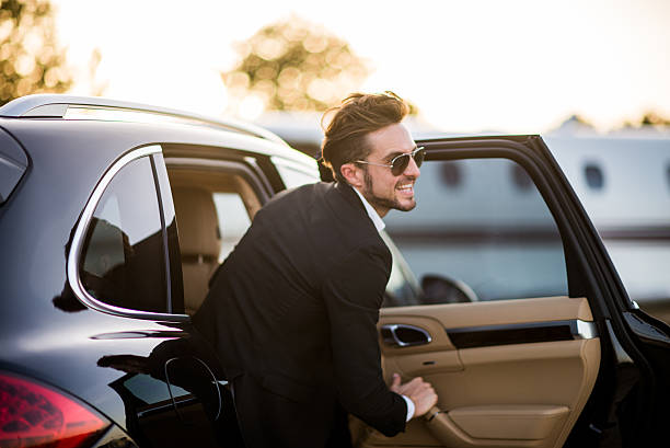 istock Man with sunglasses exits the black car 500423696