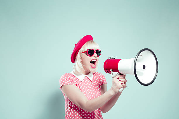 jeune jolie blonde femme criant en mégaphone - screaming shouting women human mouth photos et images de collection