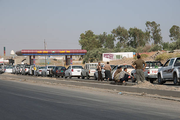 Nineveh Province, Iraq - June 21, 2014: Cars wait in line for fuel due to rationing imposed by the Kurdish government in Nineveh Province, northern Iraq, June 21, 2014. The fuel shortage was caused in part by advances by the Islamic State in Iraq and the Levant (ISIL) in other parts of Iraq. Drivers waited for hours in lines stretching several kilometers long in some cases. Fueling was allowed on alternating days based on odd- or even-numbered plates.
