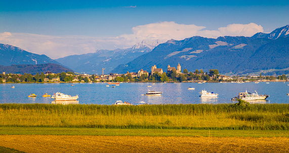 Beautiful view of boats lying in Lake Zurich with the historic town of Rapperswil in the background in golden evening light at sunset, Rapperswil-Jona, canton of St. Gallen, Switzerland.
