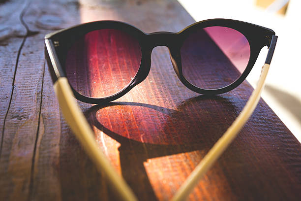 istock Sunglasses with shadow on wooden background 500428044