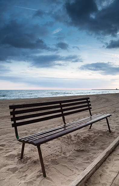istock Empty wooden bench stands on sandy beach 500428182