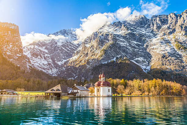 lake konigssee mit st. bartholomae pilgerkirche im herbst, bavaria - konigsee stock-fotos und bilder