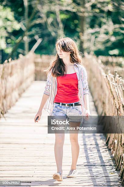 Teen Girl Walks Next To Country Wicker Fence Stock Photo - Download Image Now - 12-13 Years, 14-15 Years, Active Lifestyle