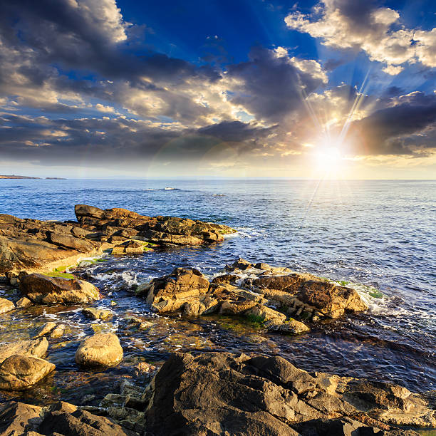 istock sea wave breaks about boulders at sunset 500429085