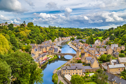 Aerial view of the historic town of Dinan with Rance river with dramatic cloudscape, Cotes-d'Armor department, Bretagne, northwestern France.