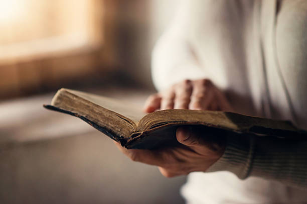 Woman with bible Unrecognizable woman holding a bible in her hands and praying bible open stock pictures, royalty-free photos & images