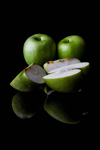istock Whole and sliced green apples from side with reflection vertical 500430018