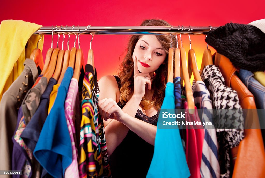 Young woman deciding what to put on Nothing to wear concept, young woman deciding what to put on  Clothing Stock Photo