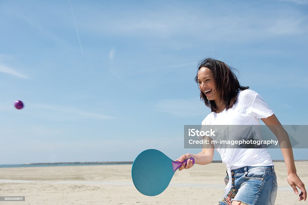 Woman playing paddle ball Portrait of a young woman playing paddle ball at the beach Beach Stock Photo