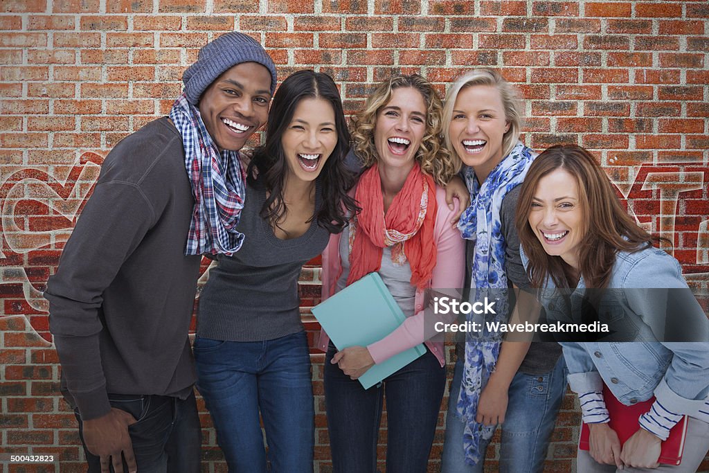 Smiling group of friends posing together Smiling group of friends posing together on brick background 20-29 Years Stock Photo