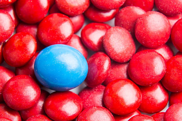 istock Focus on blue chocolate candy against heaps of red candies 500433422