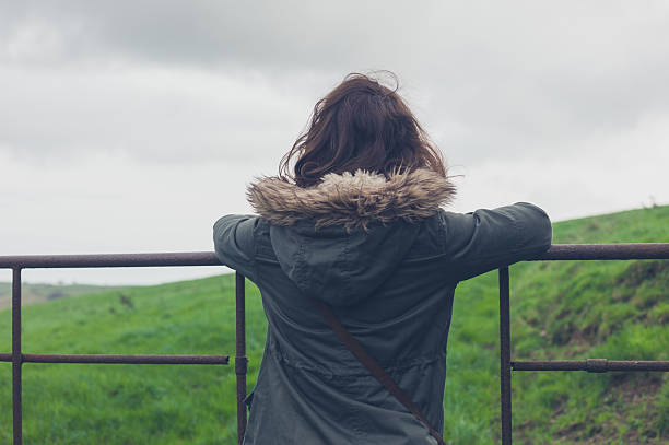 istock Woman standing by gate in countryside 500435426