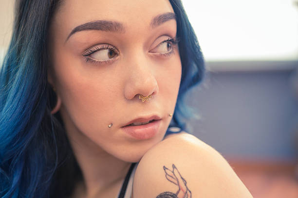 tattooed young womanwith blue hair exercising in gym pole dance tattooed young woman with bleu hair exercising in gym pole dance: really nice suicide girl. septum piercing stock pictures, royalty-free photos & images