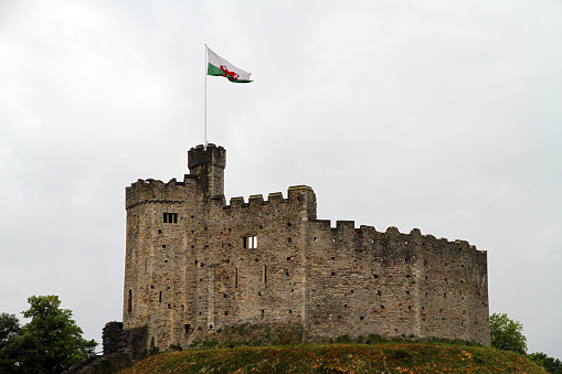 Cardiff, United Kingdom - June 17, 2011: The central keep of Cardiff Castle in Wales, with the Welsh flag flying over the battlements. 