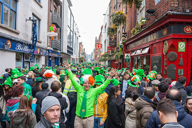 Dublin, Ireland - March 17: Saint Patrick's Day parade Dublin, Ireland - March 17, 2014: Saint Patrick's Day parade in Dublin Ireland on March 17, 2014: People wearing the typical clothes of Saint Patrick's at The Temple Bar in Dublin temple bar pub stock pictures, royalty-free photos & images