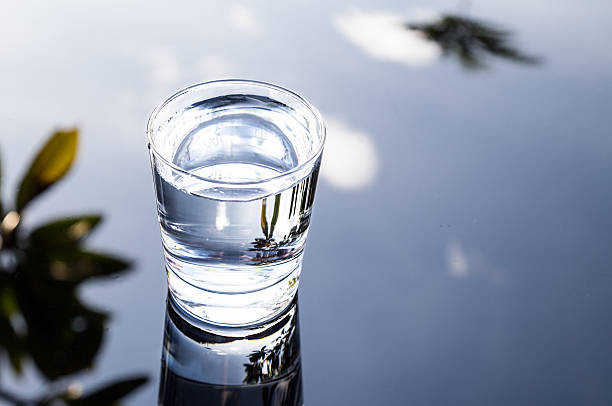 rinfrescante acqua in vetro trasparente con riflesso contro nero - reflection on the water foto e immagini stock