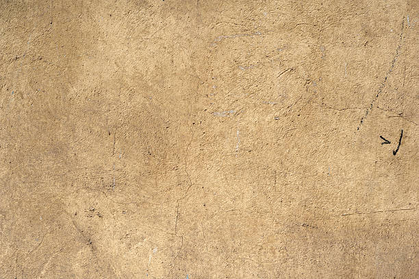 istock Texture of old wall covered with yellow stucco 500453978