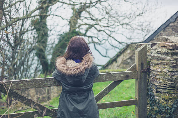 istock Young woman by gate outside barn 500458228