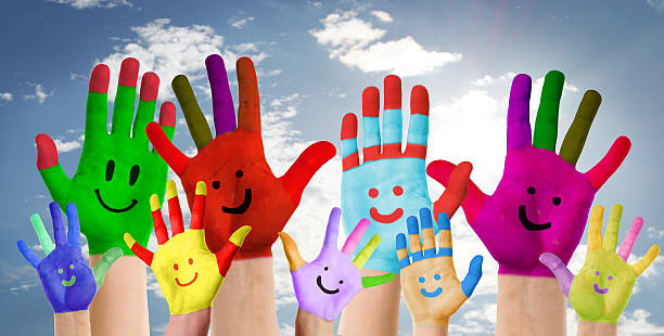 istock smiling colorful hands raised up against clouds background 500458931