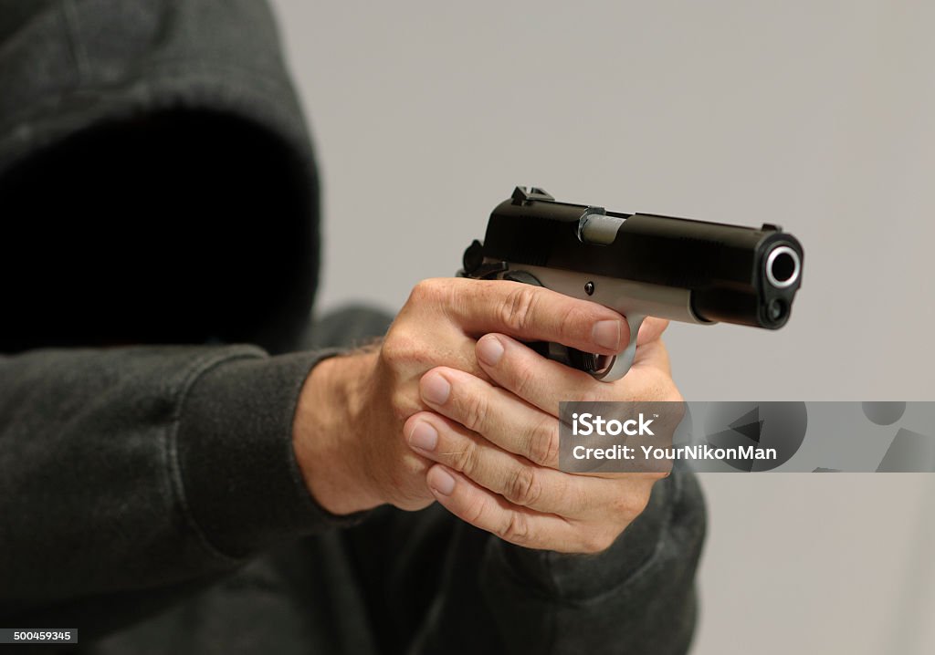 Crime with Guns Hooded man with handgun Aggression Stock Photo