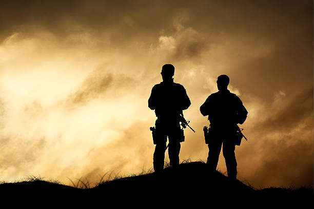 Military Men Over Look a Dramatic Firey Horizon