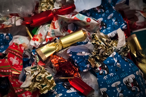 Crumpled and discarded wrapping paper and christmas crackers