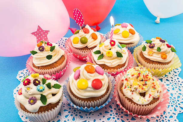 istock Birthday cupcakes with balloons on a blue background 500464558