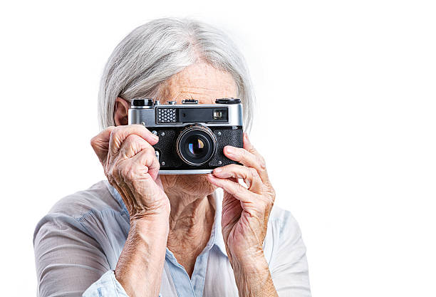 istock Senior woman shooting with a retro camera 500465080