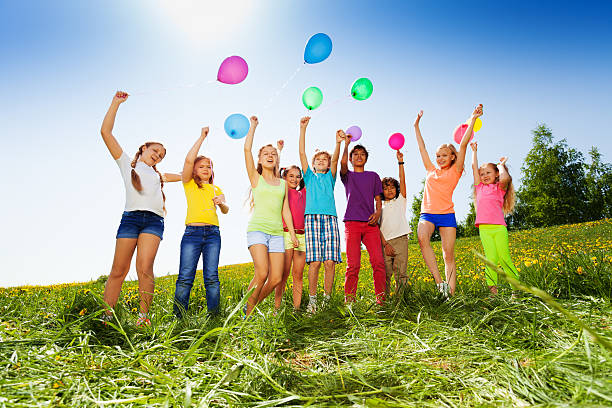 istock Jumping kids with flying balloons in summer 500472711
