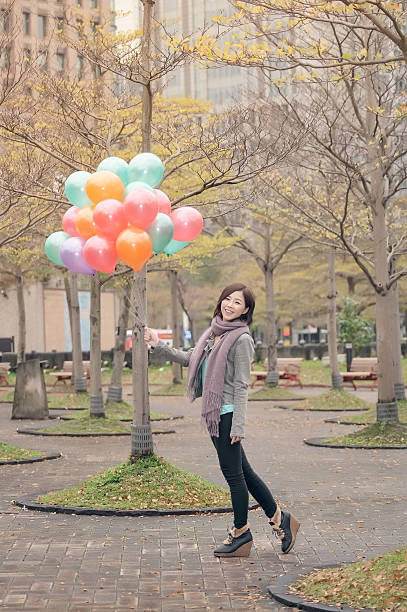 istock Young woman playing and holding balloons 500473343