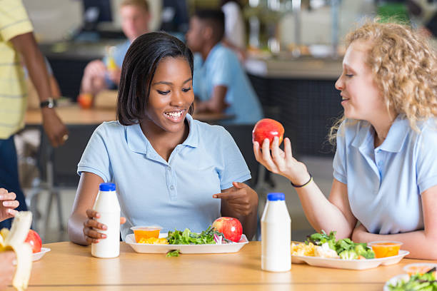 high school meninas comer o almoço juntos em lunchroom - tray lunch education food imagens e fotografias de stock